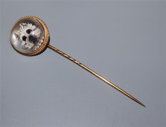 A late Victorian yellow metal and Essex crystal stick pin, decorated with the head of a terrier, 78mm.